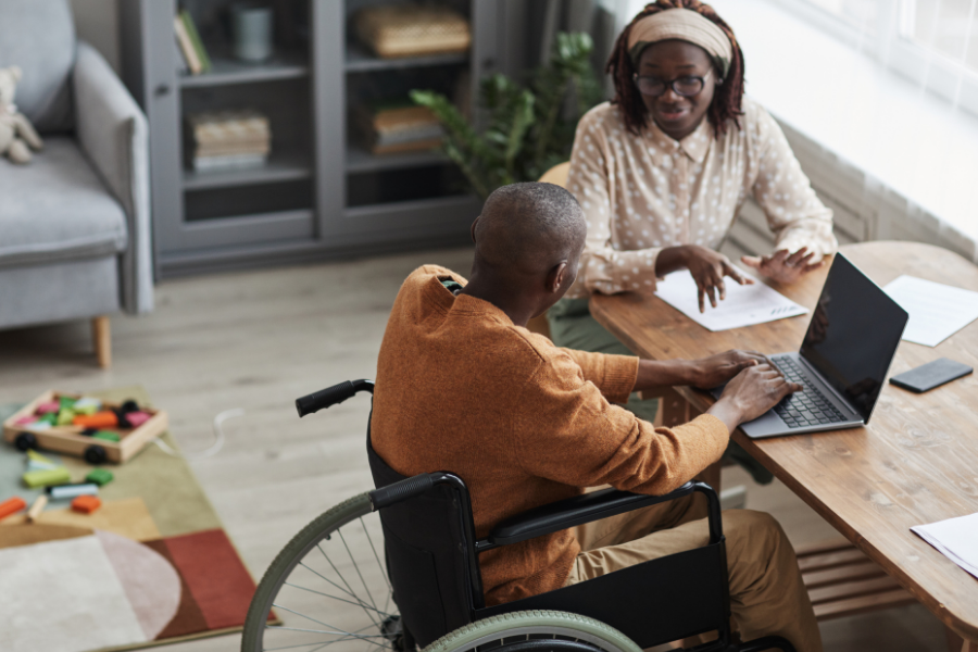 Person in a wheelchair works on a laptop.