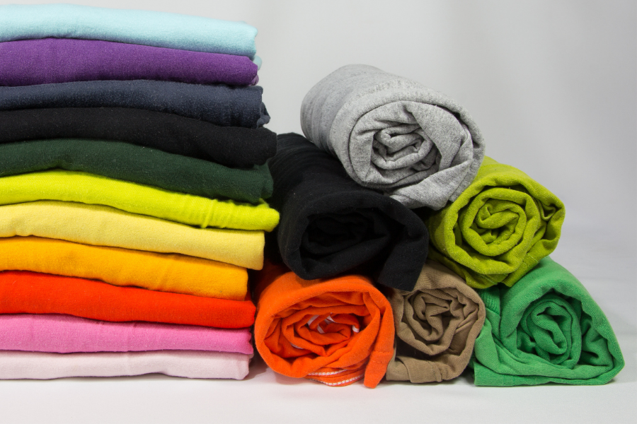 Colorful items of clothing folded in a pile, leads to clothing resources.
