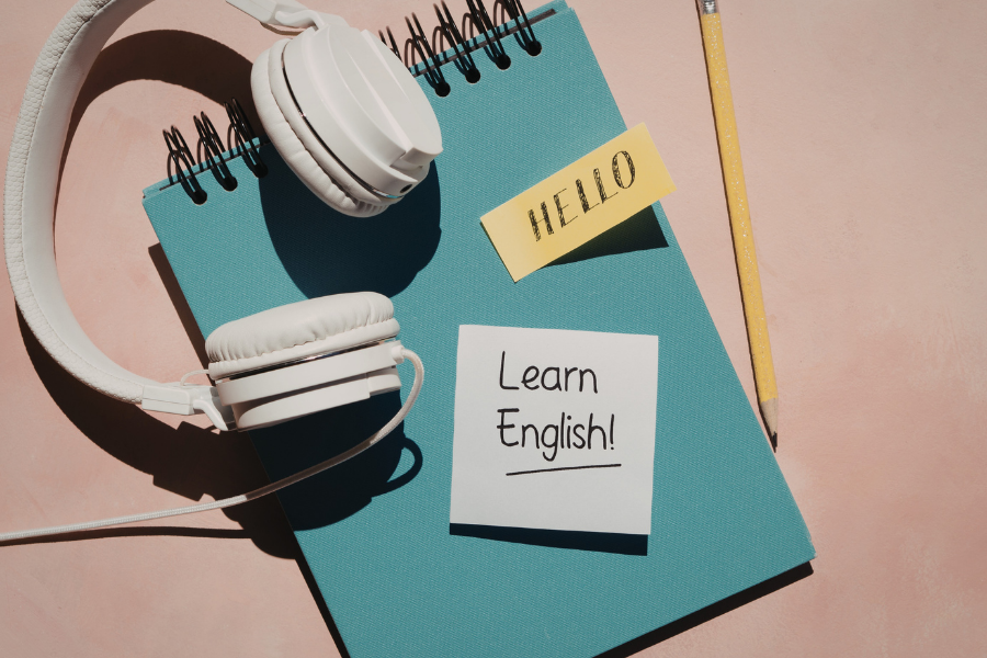 Headphones, a notebook, and a note to learn English, points to Mango Languages website.