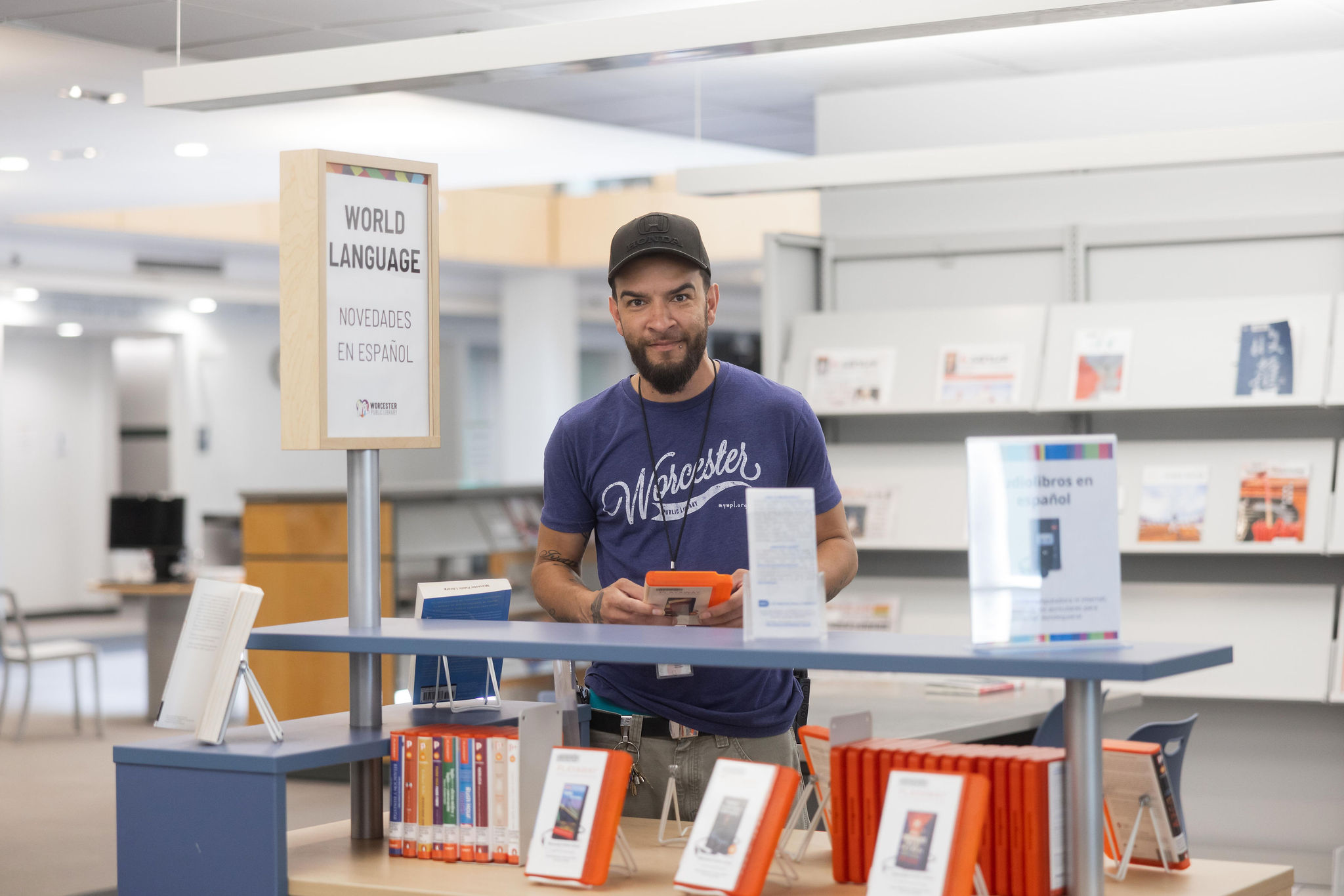 An adult in the library looking at materials, points to Adult page.
