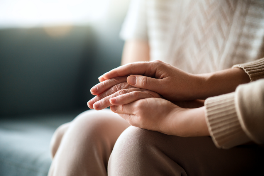 A person holding another person's hands in a supportive manner, links to domestic/sexual violence resources.